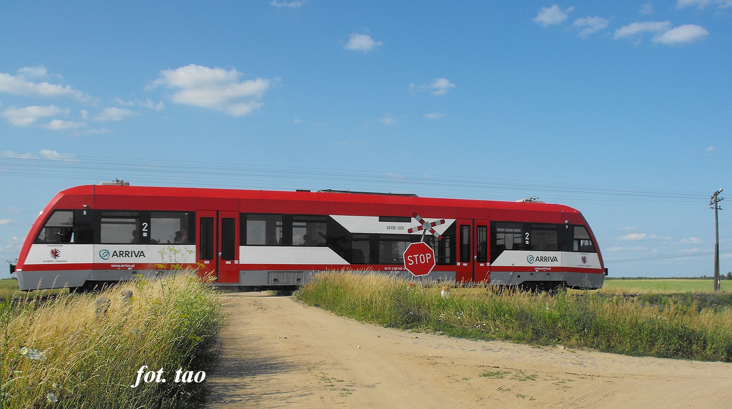Przejazd kolejowy w Pawowie­-urawiecu  k/Sierpca. Na torze szynobus do Torunia, lipiec 2013 r.
