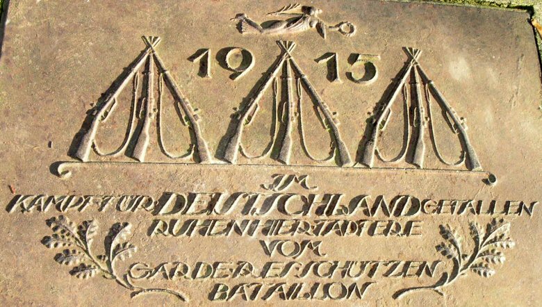 Napis na p�ycie na pomniku: 1915 <i>Polegli w&nbsp;walce o&nbsp;Niemcy spoczywaja tu waleczni z&nbsp;batalionu strzelc�w z&nbsp;Garderes</i><br>(ewentualnie  mo�e tu chodzi� nie o&nbsp;miejscowo�� Garderes, ale �wczesne okre�lenie <b>gwardyjskiego  batalionu strzelc�w</b>). 