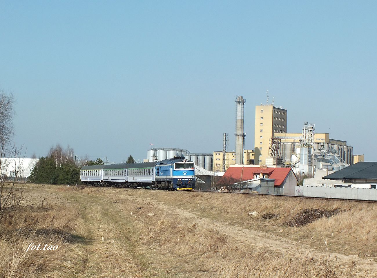 TLK Flisak w kierunku do Płocka, w oddali sierpecka dzielnica przemysłowa, marzec 2022 r.