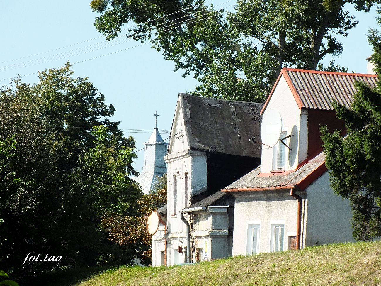 Domy przy ulicy 11-go Listopada, w gbi dzwonnica kocioa farnego, wrzesie 2021 r.